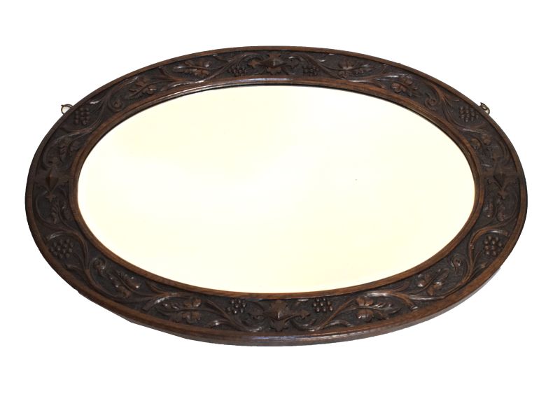 Early 20th Century oval oak framed mirror having carved grape and foliage border, 87cm x 61cm high