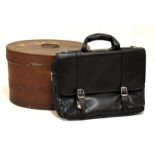 Vintage oval metal hat box with hinged cover and black holdall