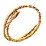 Yellow metal serpent bracelet of coiled flexible design with gem-set eyes, stamped 9ct, 18g gross