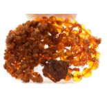 Long string of tumbled and amber beads approximately 196cm long, together with a natural amber