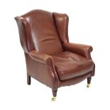 Reproduction wing armchair upholstered in wine leatherette with loose cushion on turned fluted front