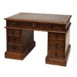 Late 19th/early 20th Century heavily carved oak twin pedestal desk fitted seven drawers, having