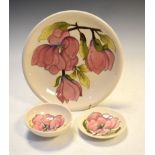 Three items of Walter Moorcroft Magnolia pattern pottery comprising: a plate, 26cm diameter, bowl,