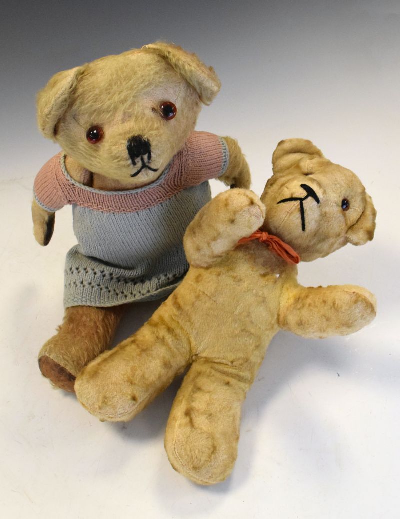 Two golden plush vintage teddy bears, one of which wearing dress, largest measuring 33cm high