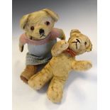 Two golden plush vintage teddy bears, one of which wearing dress, largest measuring 33cm high