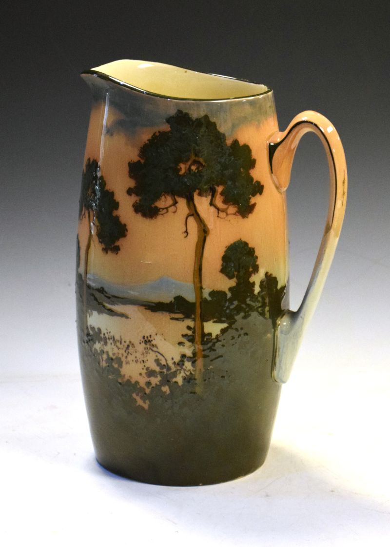 Large Royal Doulton pottery jug, decorated in shallow relief with a sunset wooded landscape,