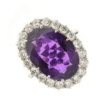 Amethyst and diamond cluster ring, stamped '18ct', the oval cut stone measuring approximately 14mm x