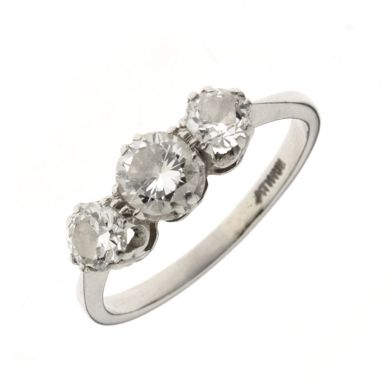 Three stone diamond ring, the white mount stamped 'atinum' having been sized, the graduated