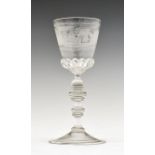 Engraved wine glass, the tapering bowl etched with a country house and landscape with perching bird,