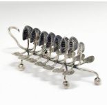 Victorian silver toast rack, having seven branches with lily pad terminals standing on four ball