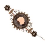 Unmarked yellow metal bar brooch of scroll and flowerhead design set central brown topaz-coloured