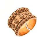 Unmarked yellow metal band ring of broad design with band of flowerheads within studded borders,