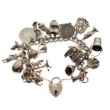 Silver curb-link charm bracelet with padlock with approximately twenty-six silver and white metal