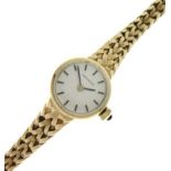 Movado - Lady's yellow metal wristwatch, silvered circular dial with baton hour markers, to a