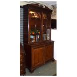 Reproduction mahogany two section bookcase having architectural pediment and dentilled cornice,