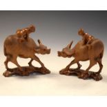 Pair of 20th Century Chinese carved wooden figures, each riding a water buffalo, 14.5cm high (2)