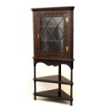 Late 19th/early 20th Century heavily carved dark oak floor standing corner display cabinet, 90cm