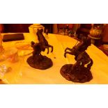A pair of bronze effect figurines depict