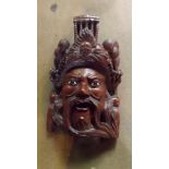 An oriental carved wooden wall mask depi