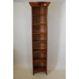 An Arts and Crafts oak open bookcase with adjustable shelves, bears label B. Maggs and Co, Queens