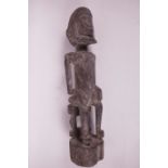 An African carved wood ceremonial figure of a seated man, possibly Dagon, 13" high