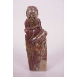 A Chinese soapstone seal carved with a seated sage, seal end blank, 4½" long