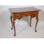 A Georgian style walnut lowboy, with feather banded inlaid top and three drawers, raised on cabriole