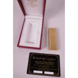 A Cartier gold plated cigarette lighter of ribbed design in original box with guarantee card