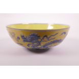 A Chinese yellow ground porcelain bowl with blue and white dragon decoration, 6 character mark to