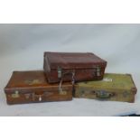Two vintage leather travelling cases and one canvas covered case, largest 28" x 18", 9"