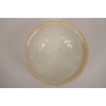 A Chinese Song style celadon glazed pottery dish with raised underglaze decoration of boys and