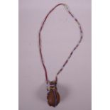 An African tribal dried gourd poison flask on a bead chain, 3½"