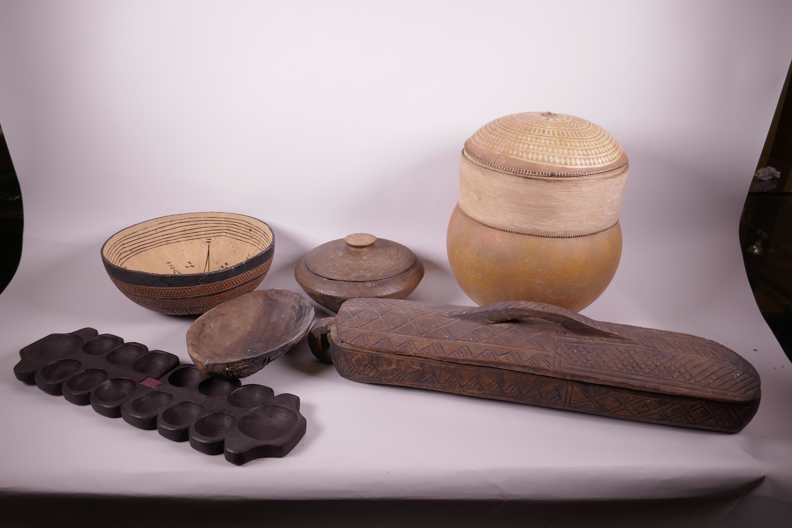 A quantity of African tribal wood and gourd vessels and containers, largest 13" high