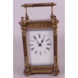 A brass cased carriage clock, the case with architectural columns and pierced geometric