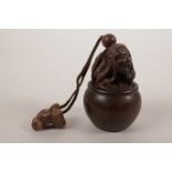A Japanese carved hardwood inro in the form of a long haired figure in a barrel, impressed mother of