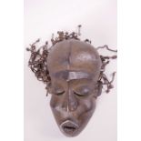 An African carved wood tribal mask with string hair, (Ivory Coast), 9½" long
