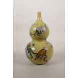 A Chinese yellow ground double gourd porcelain vase with enamel decoration of a bird amongst vines