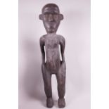 A tall African carved hardwood standing figure, 25" tall