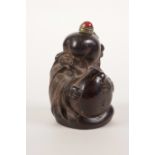 A Chinese carved horn snuff bottle in the form of Shao Lao with a large peach, 2½" high