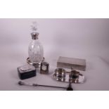 A cut glass silver mounted decanter and hallmarked silver coaster, a silver trinket box, clock, a