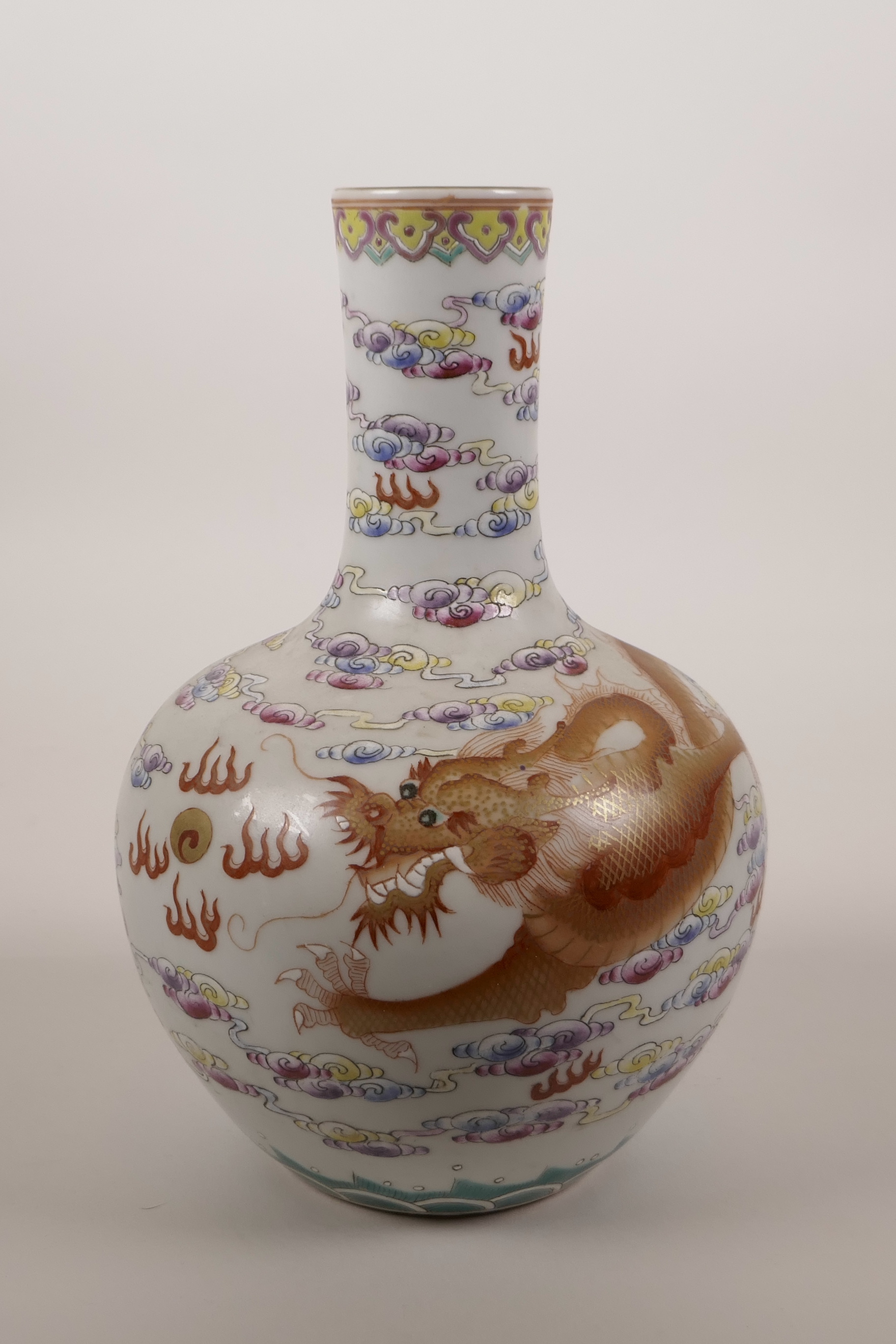 A Chinese polychrome porcelain vase decorated with a red and gilt dragon chasing the flaming