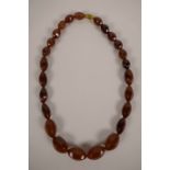 A faux amber necklace with graduated and faceted beads, 24" long