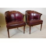 A pair of mahogany framed leather tub chairs on turned supports, 32" high