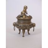 A Chinese brass censer, with bird and blossom decoration, raised on tripod supports, with a