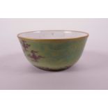 A Chinese pea green ground porcelain tea bowl with dragon and flaming pearl decoration, 6