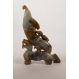 A Chinese mottled grey jade taper holder/candlestick with carved dragon decoration, 7" high