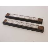 A pair of Chinese hardwood scroll weights with inset white metal plaques, 12" long