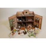 A vintage doll's house with furniture including metal Dinky kitchen