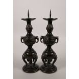 A pair of Japanese bronze candlesticks in the form of vases on stands, 9½" high