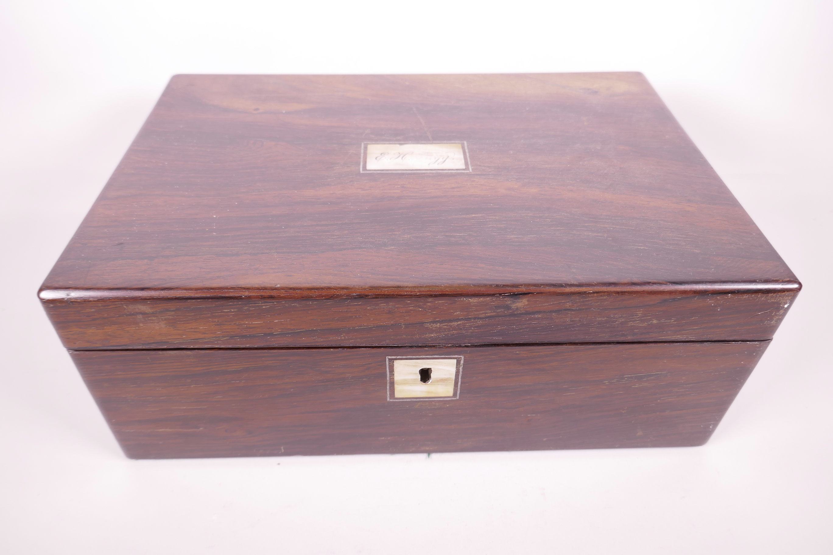 A C19th rosewood writing slope, with mother of pearl plaque to lid, the fitted interior with two